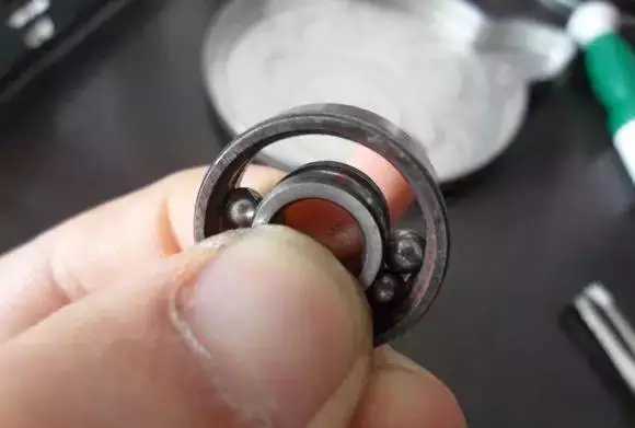 用手將軸承拿起，需要注意要向有滾珠的方向頂住